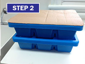 Two blue boxes with a cardboard lid on top of them.