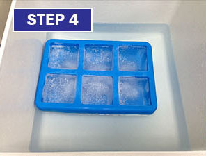 A blue ice cube tray sitting in the middle of an open freezer.